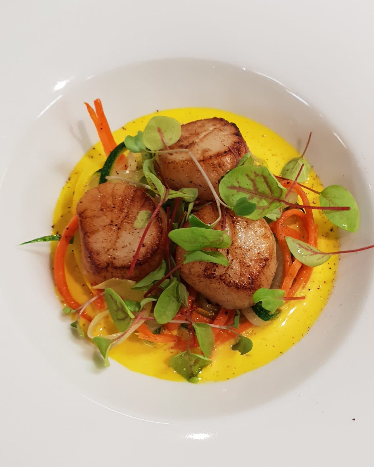 Saint-Jacques poêlées, coulis safrané & julienne de légumes